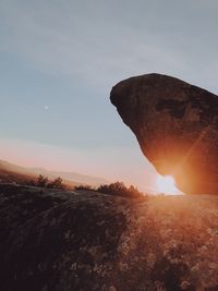 Rock formation on land against sky during sunset