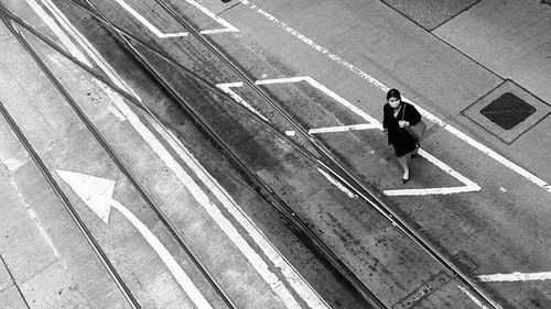 High angle view of woman wearing mask walking on road in city