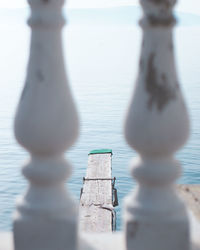 Close-up of metal railing against water