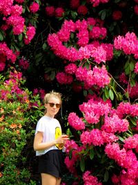 Teenage girl standing by pink flowers