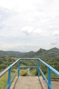 Empty road leading towards mountains against sky