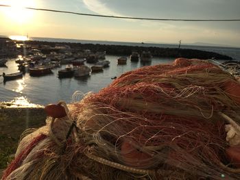 Close-up of fishing net at harbor during sunset
