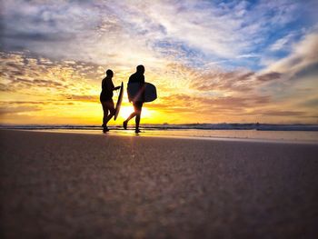 Silhouette of people walking on beach