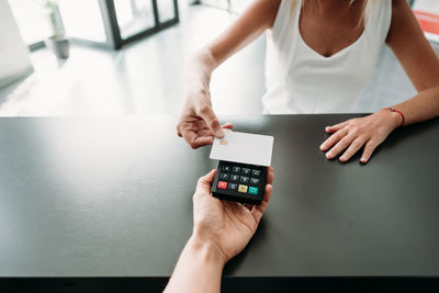 Unrecognizable woman paying in shop through contact less credit card. shopping