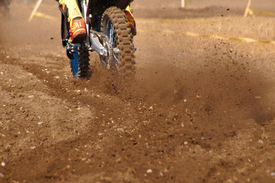 Low section of person riding horse in mud
