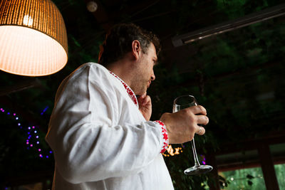 Man holding wineglass at night