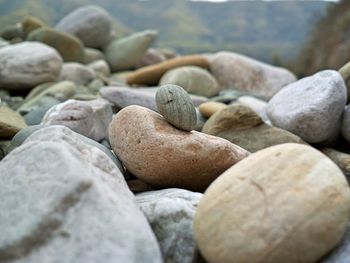 Nature theories, uttarakhand, india- bokeh of weathered pebble stacked by shore