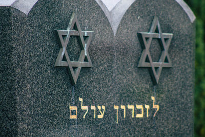 Close-up of arrow sign on cemetery