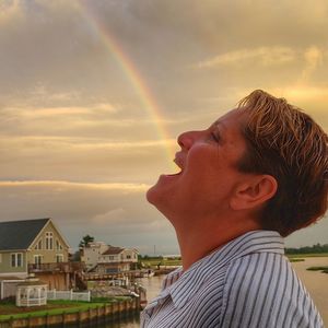 Portrait of man against rainbow in sky