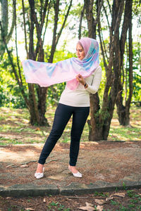 Full length of a woman standing in the forest