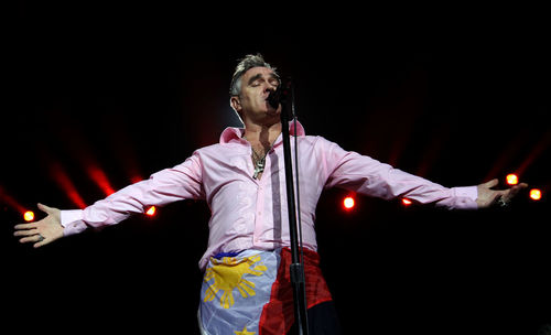 Man singing while standing on stage