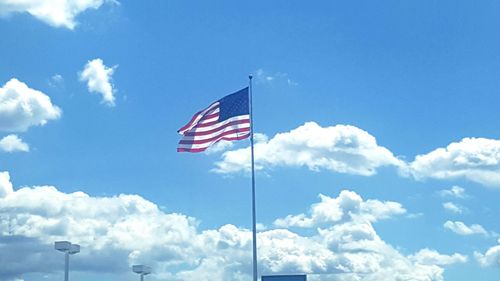 Low angle view of american flag against blue sky