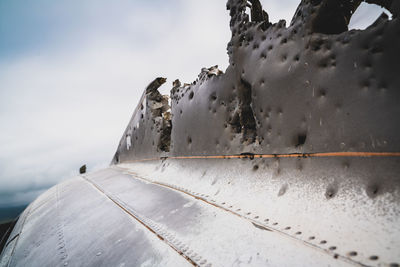 Close-up of airplane against sky during winter