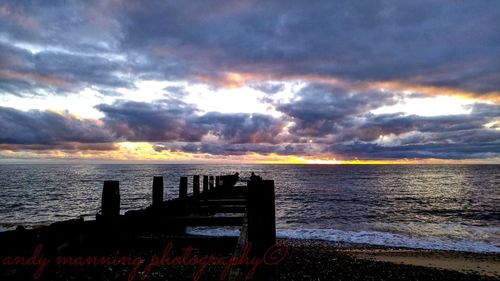Pier on sea at sunset