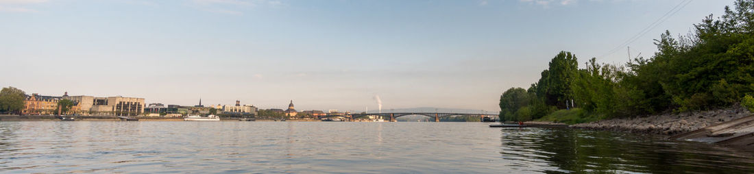 Scenic view of river against sky in city