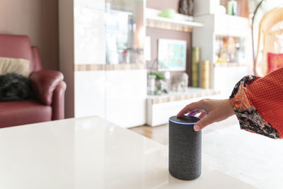 Midsection of woman using mobile phone while sitting on table