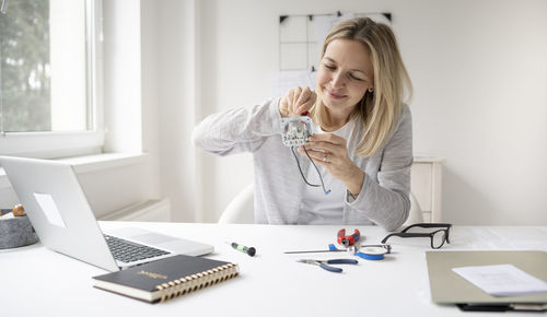 Young woman using phone on table