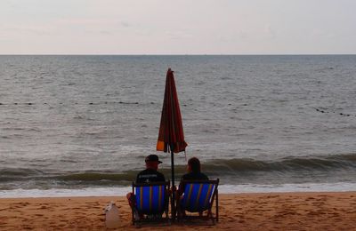 Rear view of man on beach against sky