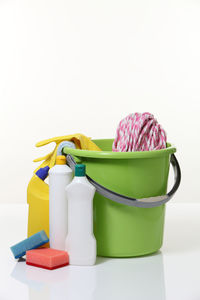 Close-up of bucket with cleaning equipment on white background