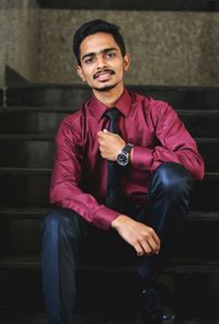 Portrait of young man sitting on steps