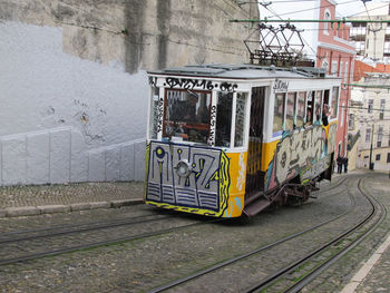 Graffiti on wall by railroad tracks in city