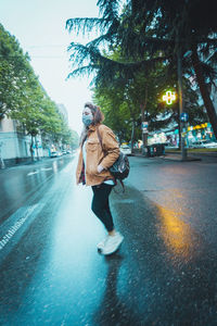 Woman with umbrella on street in city