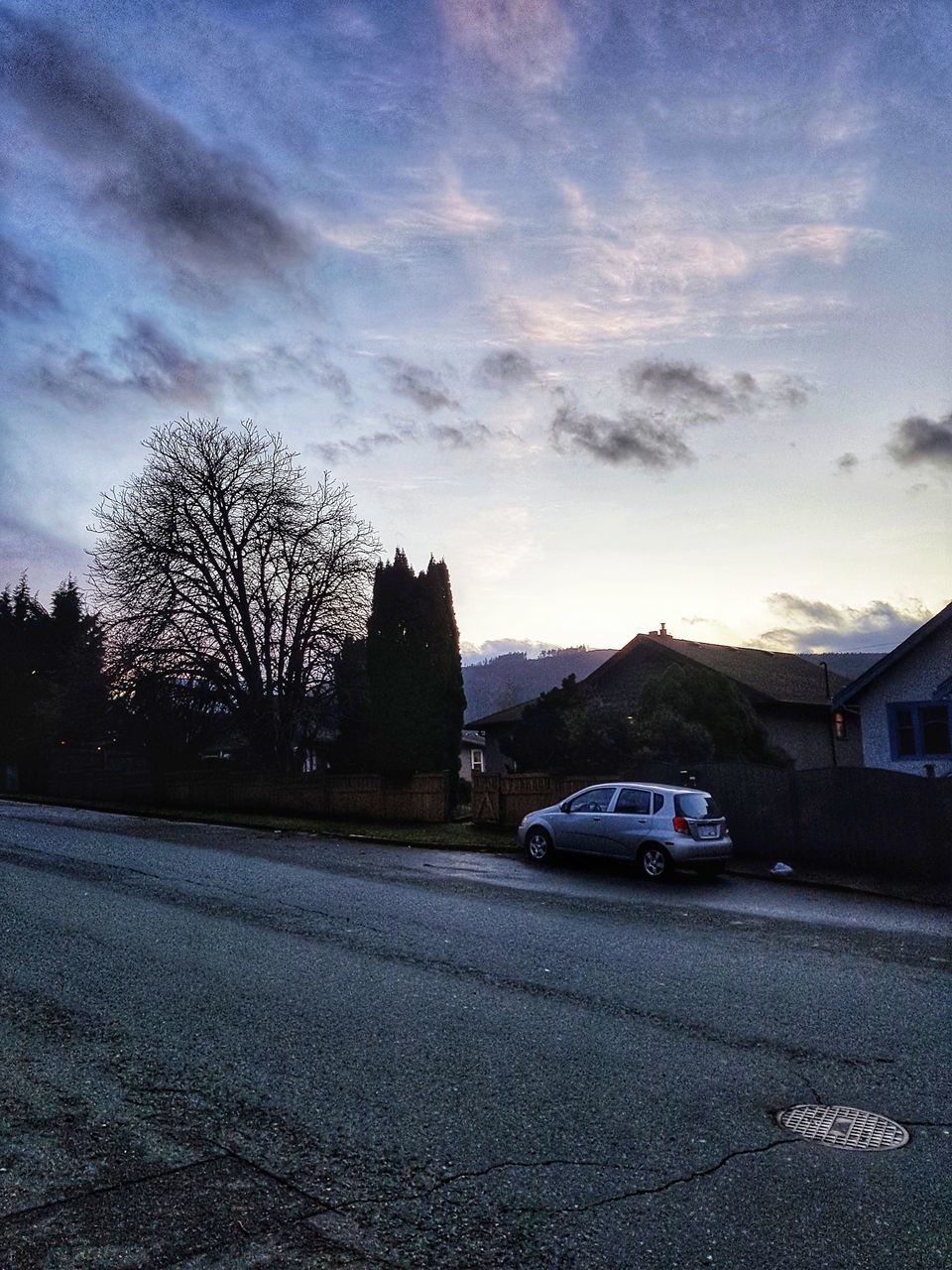 CARS ON ROAD AMIDST BUILDINGS AGAINST SKY