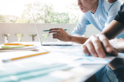 Cropped image of businessmen using laptop in office