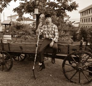Man sitting on bicycle against trees