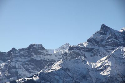 Scenic view of snowcapped mountains against clear blue sky