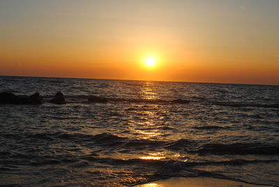 Scenic view of sea against orange sky