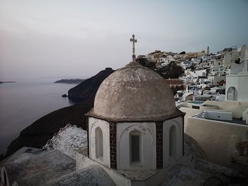 Traditional building by sea against sky