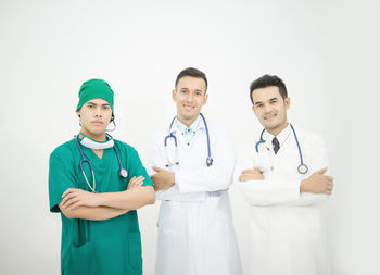 Portrait of doctors standing against white background