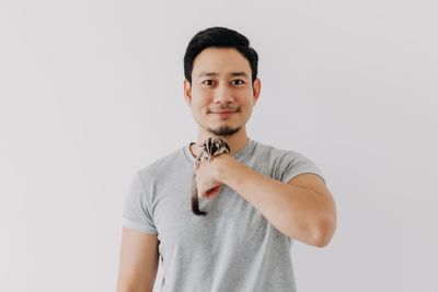 Portrait of young woman standing against white background