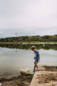 Young boy dipping toes in the water at lake bastrop