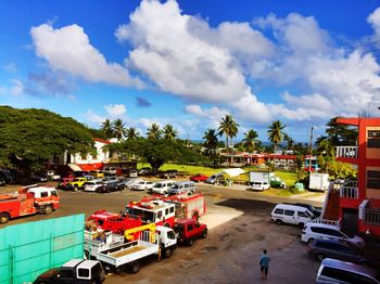 High angle view of land vehicles at parking lot against cloudy sky
