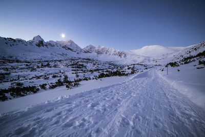 Scenic view of snow covered mountains against sky at night