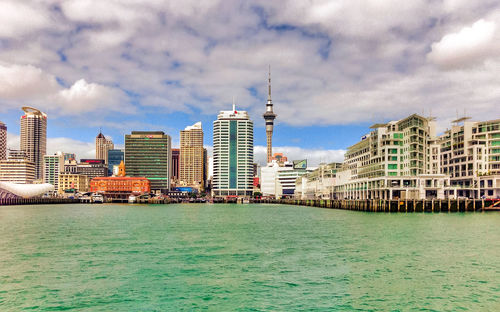 View of buildings in city against cloudy sky