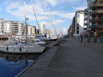 Boats moored at harbor against buildings in city