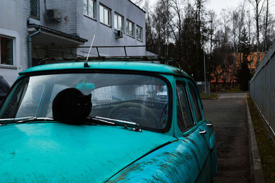 Car on road by buildings in city