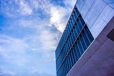 Low angle view of modern building against cloudy sky