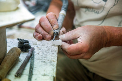 Midsection of man working on wood