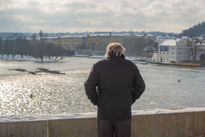 Rear view of woman looking at city during winter