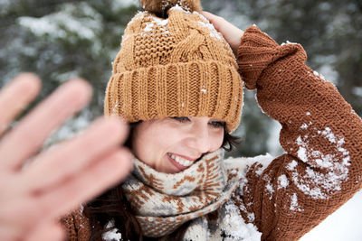 Smiling young woman standing in snow