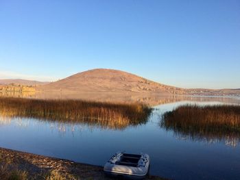 Scenic view of lake against clear blue sky