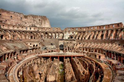High angle view of coliseum against cloudy sky