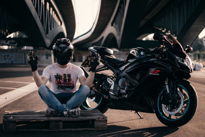 Man sitting on road in city