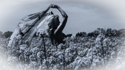 Rear view of woman standing on field against sky