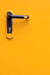 Close-up of yellow door against orange background