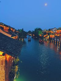 Boats in sea with houses in background